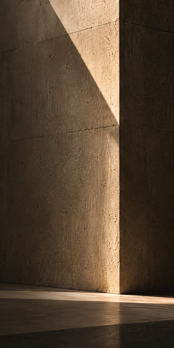 Warm sunlight and diagonal shadows on a monumental travertine column
